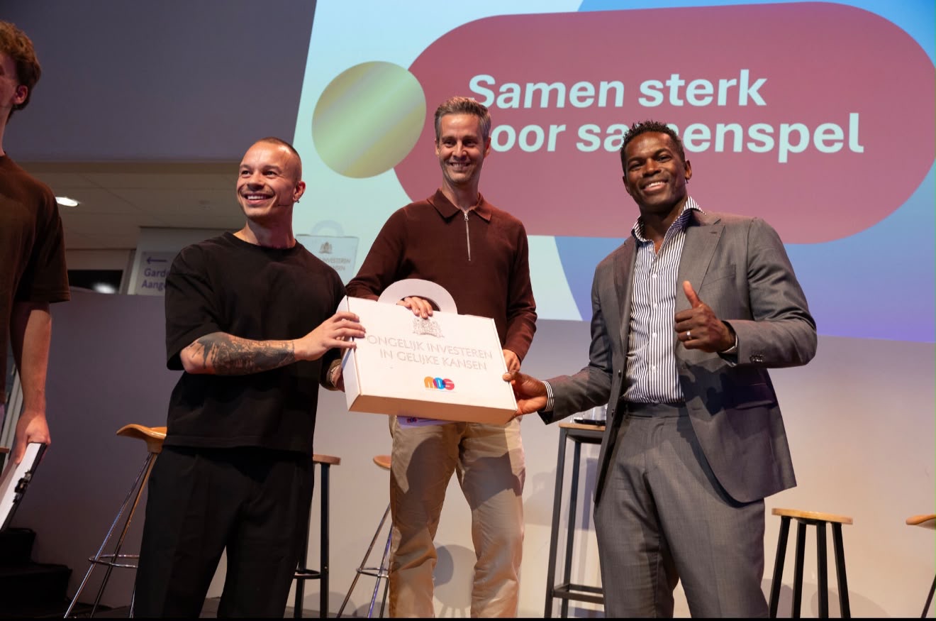 Nick op het podium tijdens de Sportieve Troonrede van MOS, voor een volle zaal.